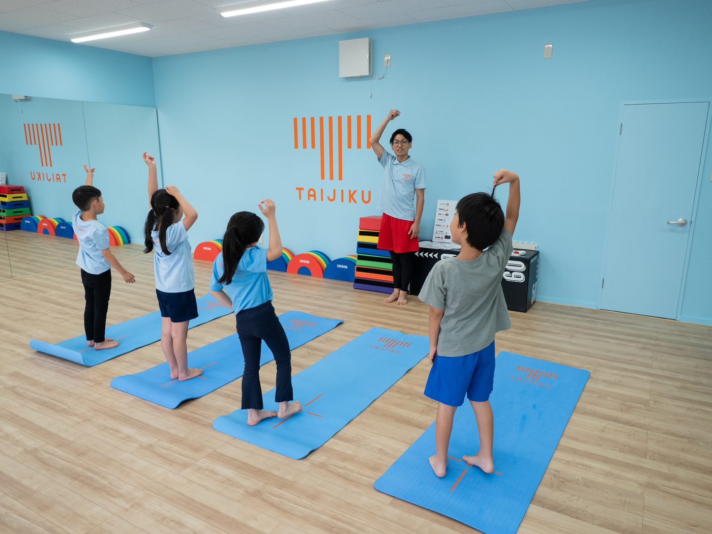 トレーナーと一緒にストレッチをする子どもたち